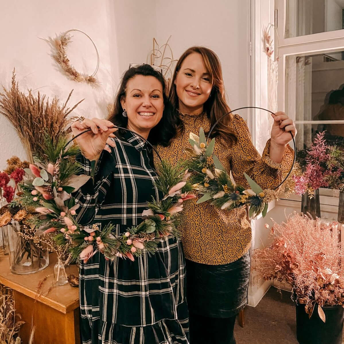 Zwei Personen halten ihre fertigen Weihnachtsdeko-Ringe – weihnachtsdeko workshop berlin, deko ring weihnachten.