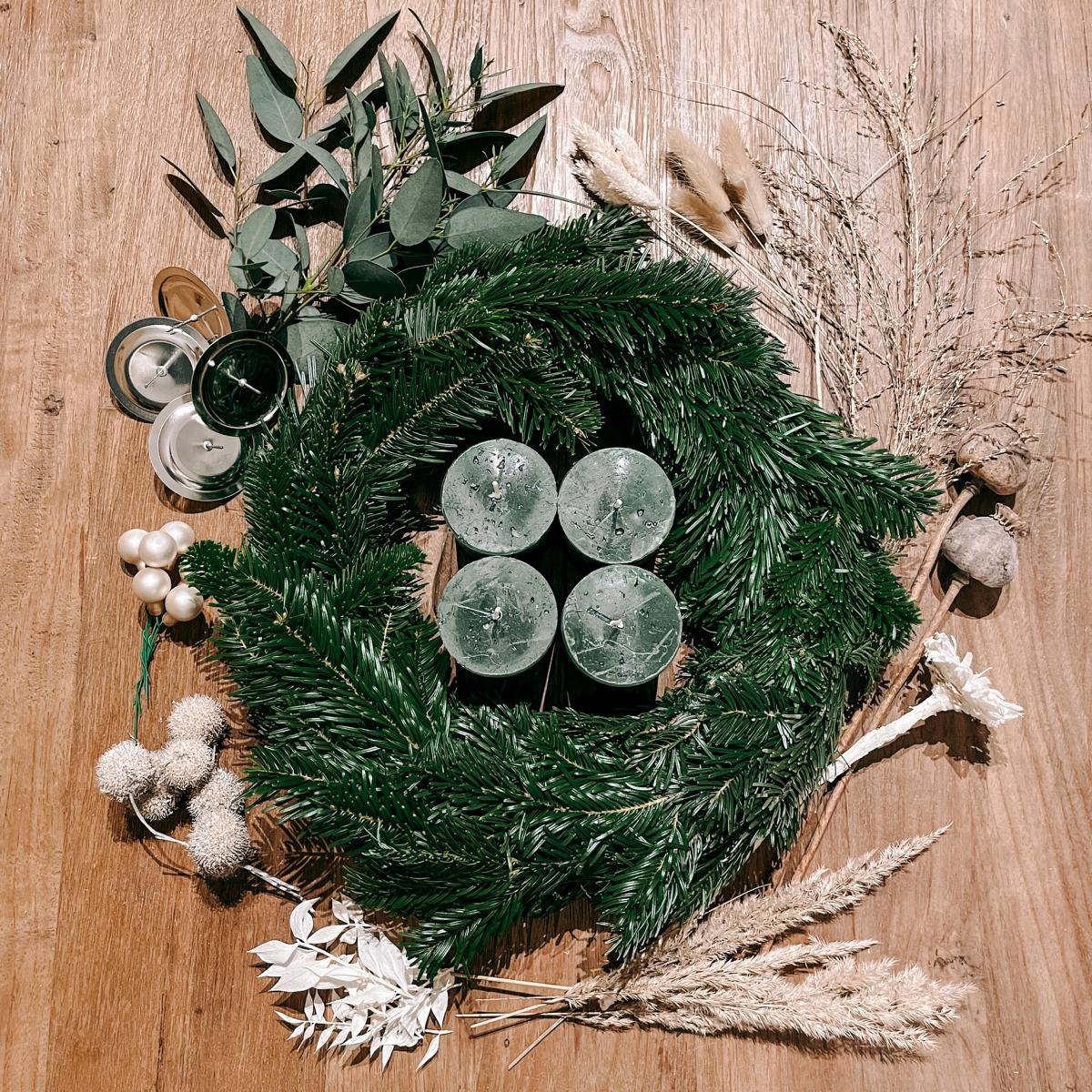 Kranz mit grünen Kerzen, Blumen und Kugeln – Adventskranz Hänsel mit Naturmaterialien gestalten.
