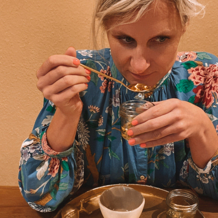 Frau riecht an Kräutern mit Löffel – kräutertee workshop, DIY Tee, Teamevent.