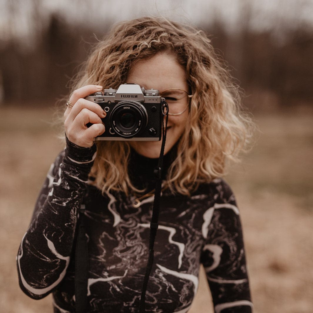 Frau hält Kamera vor Gesicht – Fotokurs Grundlagen Blende, ISO und Belichtungszeit, keine Vorkenntnisse nötig.