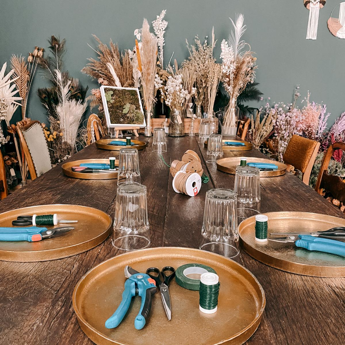 Nahaufnahme Tisch mit Werkzeugen, Trockenblumen und Materialien – diy blumenkrone, flower crown workshop