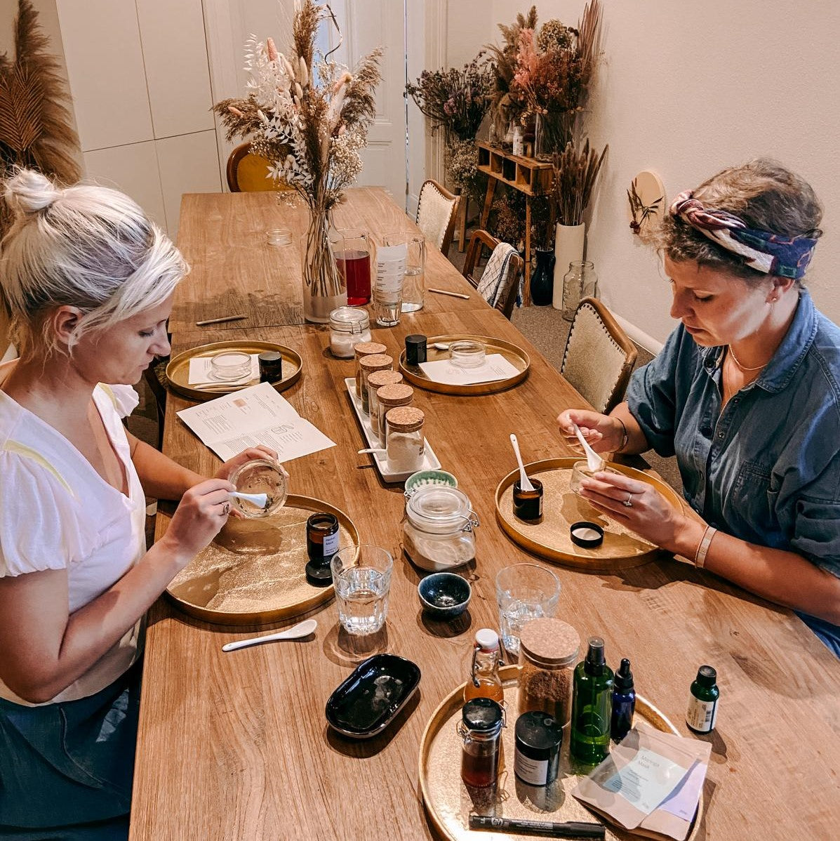 Zwei Frauen mischen ihre Masken auf dem Tisch – Workshop für vegane Hautpflege.
