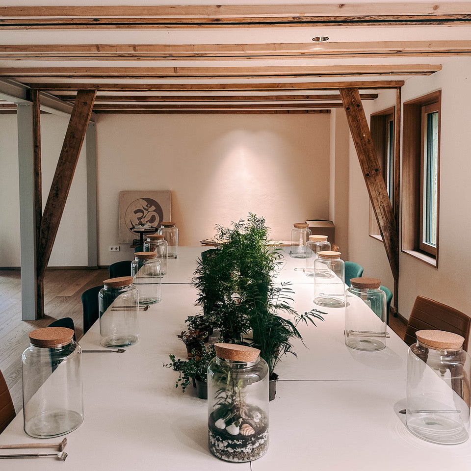 Vorbereiteter Workshop Tisch mit Materialien zum Flaschengarten Gestalten beim kreativen Team Event von GRIMMS GARTEN