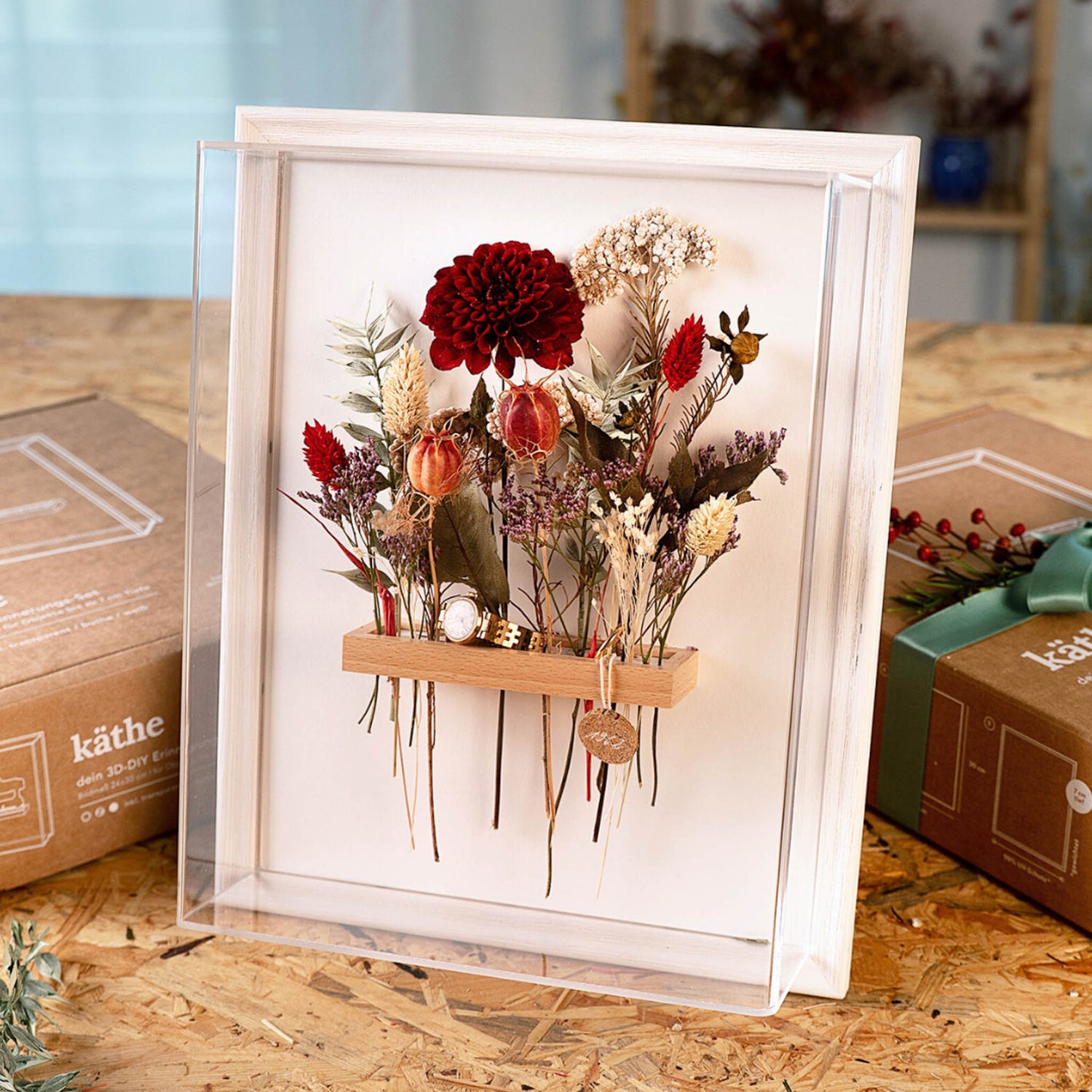 Bilderrahmen mit Glas, Trockenblumen in Rot, Weiß und Eukalyptus dahinter – trockenblumen kunstwerk workshop.