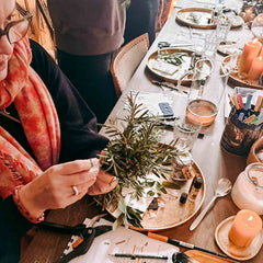 Hände binden frischen Rosmarin zusammen, Vorbereitung für einen spirituellen Kräuterworkshop
