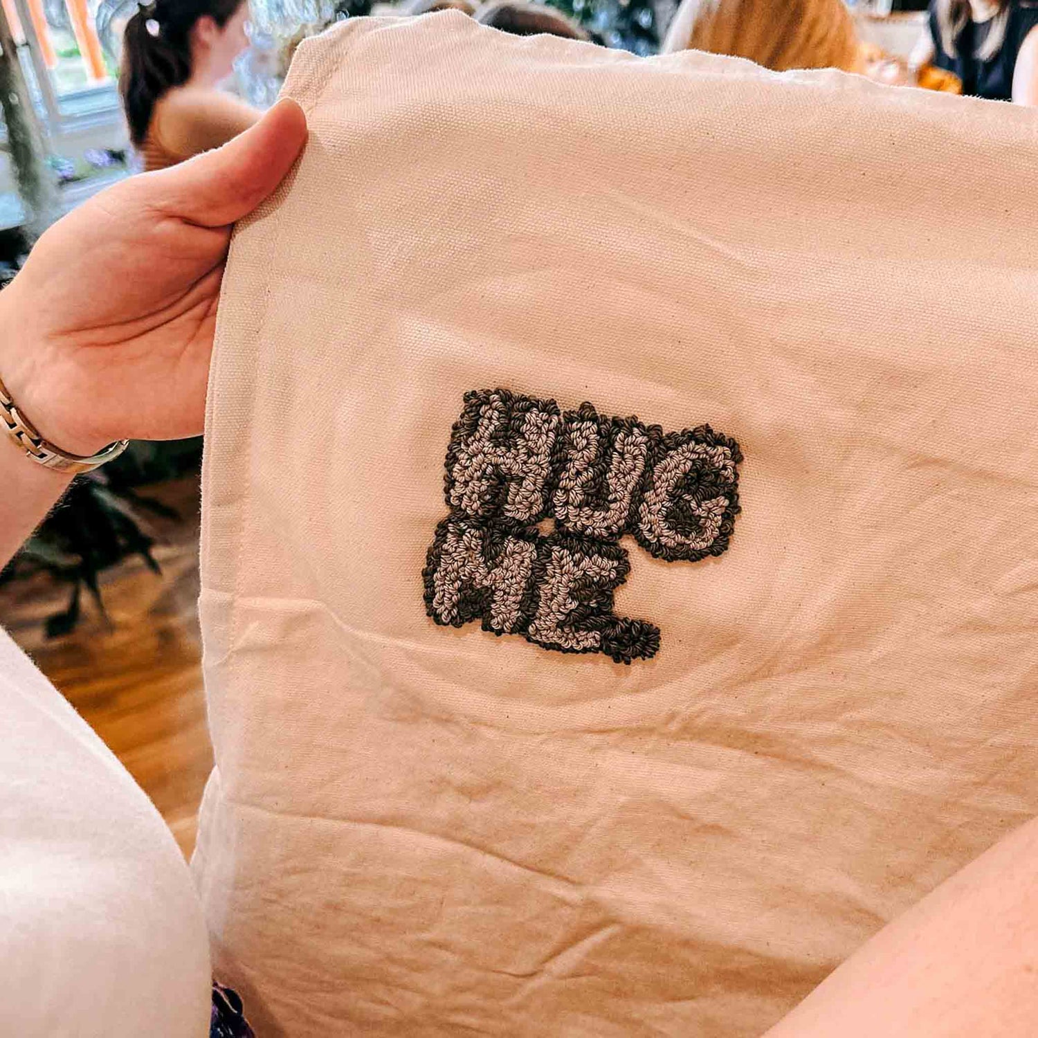 Weißer Beutel mit ‚Hug Me‘ in Grau und Schwarz gestickt – Punch Needle Workshop bei Grimms Garten