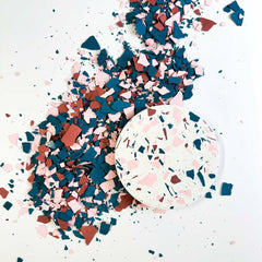 Terrazzo-Chips in Dunkelblau, Rot und Pink für kreativen Terrazzo-Workshop dekorativ verteilt