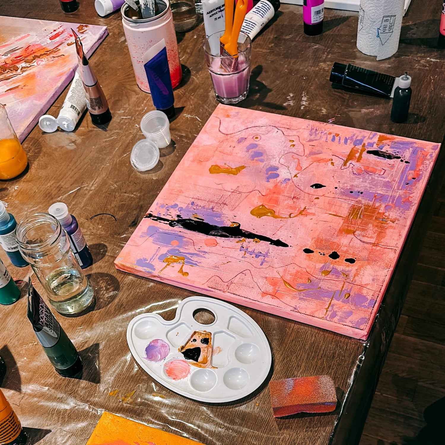 Leinwand mit abstrakter Acrylkunst in Pinktönen beim kreativen Mal Workshop von GRIMMS GARTEN Berlin
