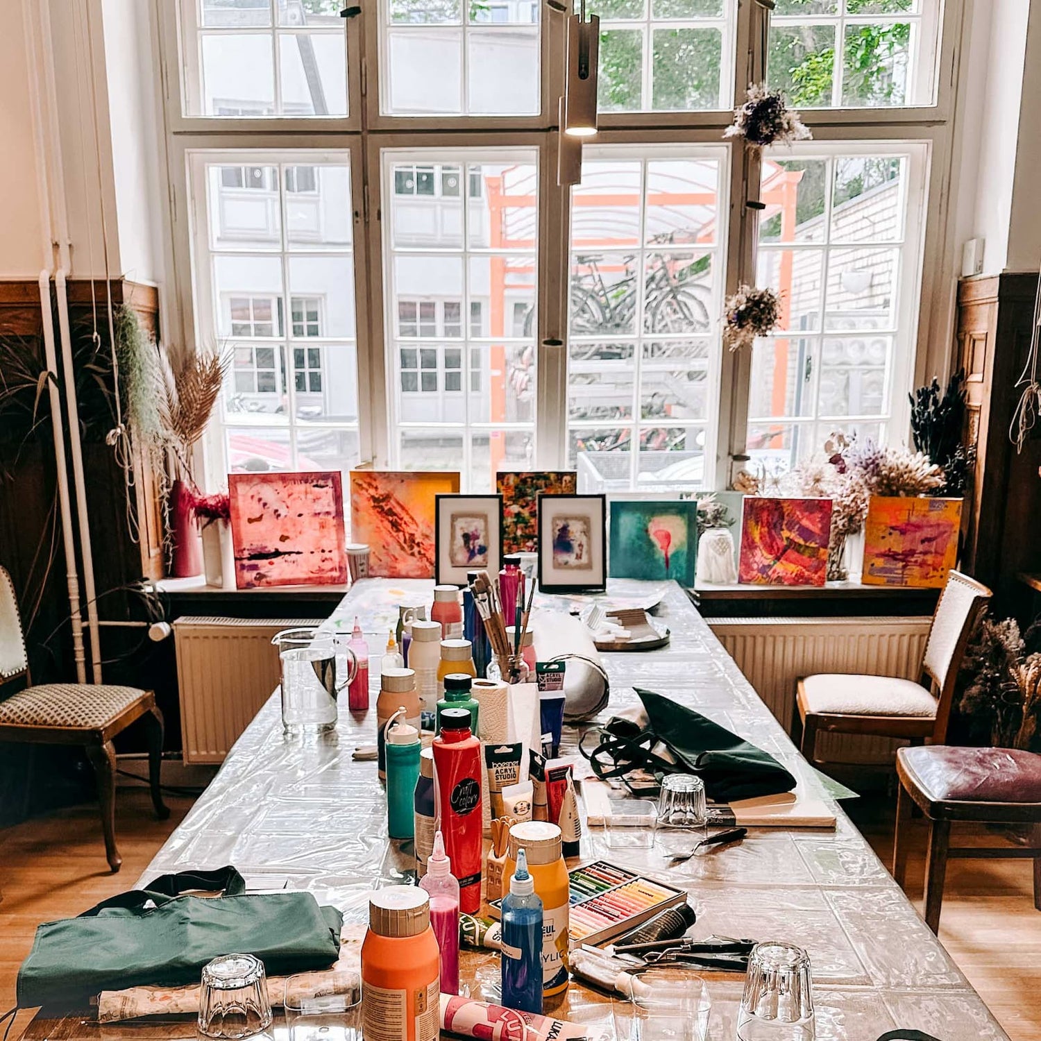 Vorbereiteter Tisch mit Acrylfarben, Pinseln und kreativen Materialien für den Abstract Painting Workshop von GRIMMS GARTEN Berlin