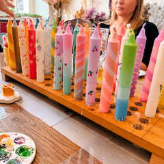 Verschiedene bemalte Dip Dye Kerzen im Kerzenständer beim kreativen Kerzen Workshop und Team Event von GRIMMS GARTEN in Berlin