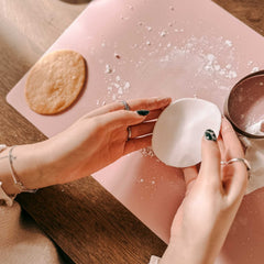 Hände platzieren weißen ausgestochenen Fondant auf einem Osterkeks beim Osterkekse Workshop von GRIMMS GARTEN, kreativer Backkurs in Berlin