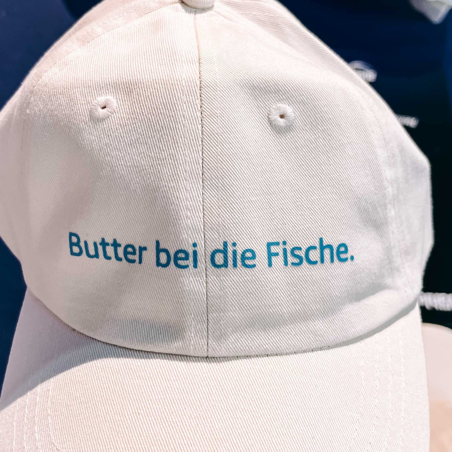 Custom bestickte Cap mit blauer Schrift beim kreativen Caps besticken Workshop von GRIMMS GARTEN Berlin