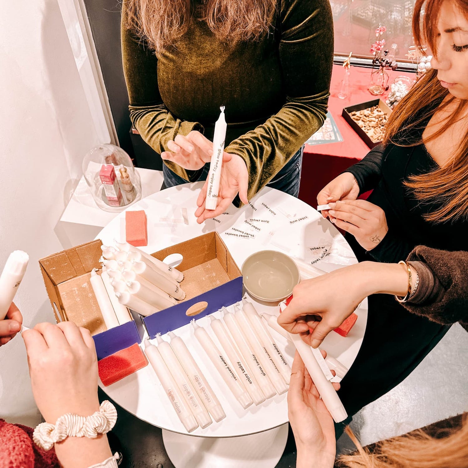 Personen gestalten Kerzen und bringen Tattoo-Motive auf beim Kerzen Tattoo Workshop von GRIMMS GARTEN, kreatives Teamevent in Berlin