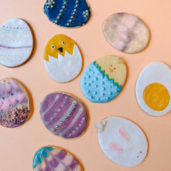 Viele fertig bemalte Osterkekse mit unterschiedlichen Motiven und Farben auf dem Tisch beim Osterkekse Workshop von GRIMMS GARTEN, Kreativkurs Berlin