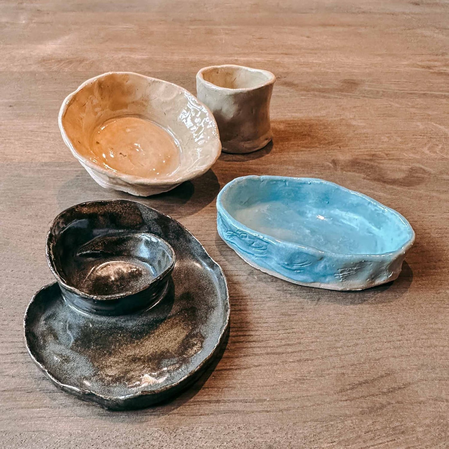 Vier verschiedene Keramikstücke in unterschiedlichen Farben aus dem Töpferkurs von GRIMMS GARTEN, kreativer Keramik Workshop und DIY Kurs in Berlin