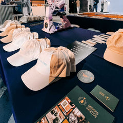 Mehrere fertig bestickte Caps auf dem Tisch beim kreativen Caps Workshop und Teamevent von GRIMMS GARTEN Berlin
