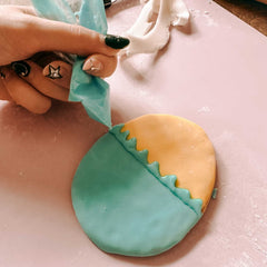 Hand verziert Osterkeks mit Streifen aus Zuckerguss aus Spritztüte beim Osterkekse Workshop von GRIMMS GARTEN, kreativer Backkurs in Berlin