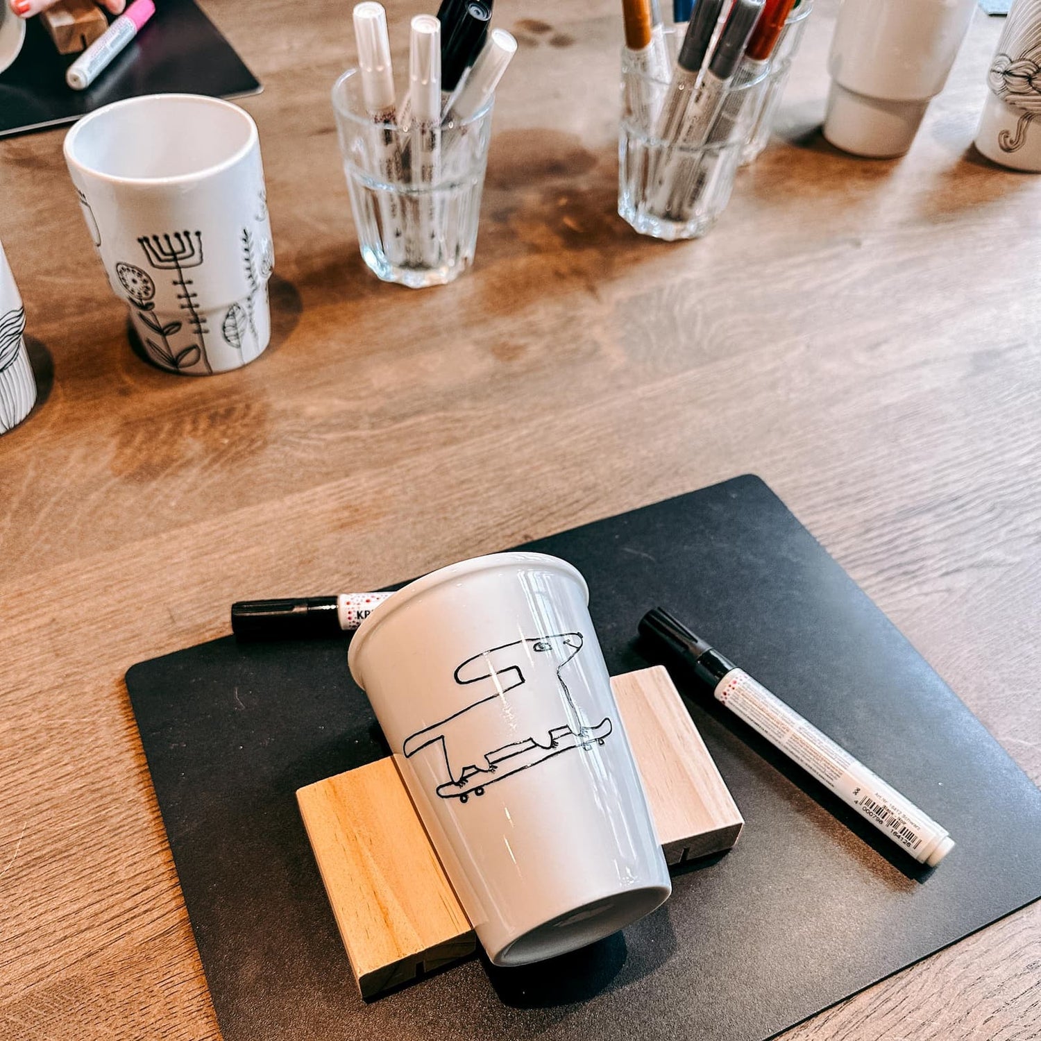 Keramik To-Go Becher mit gemaltem Hund auf Skateboard beim Keramik bemalen Workshop von GRIMMS GARTEN, DIY Kreativkurs in Berlin