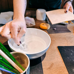 Hand legt Schablone in Schüssel ab, Vorbereitung für kreativen Workshop von Grimms Garten