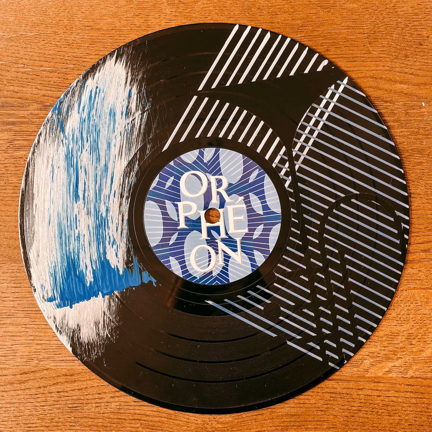 Schallplatte mit weiß-blauer Farbgestaltung im Wellenmuster mit Schaumoptik beim Vinylplatten bemalen Workshop von GRIMMS GARTEN, Kreativkurs in Berlin