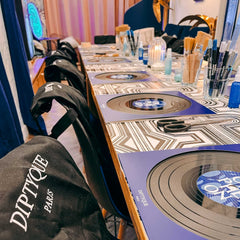 Tisch mit vorbereiteten Arbeitsplätzen, Schallplatten und Materialien beim Vinylplatten bemalen Workshop von GRIMMS GARTEN, Kreativkurs in Berlin