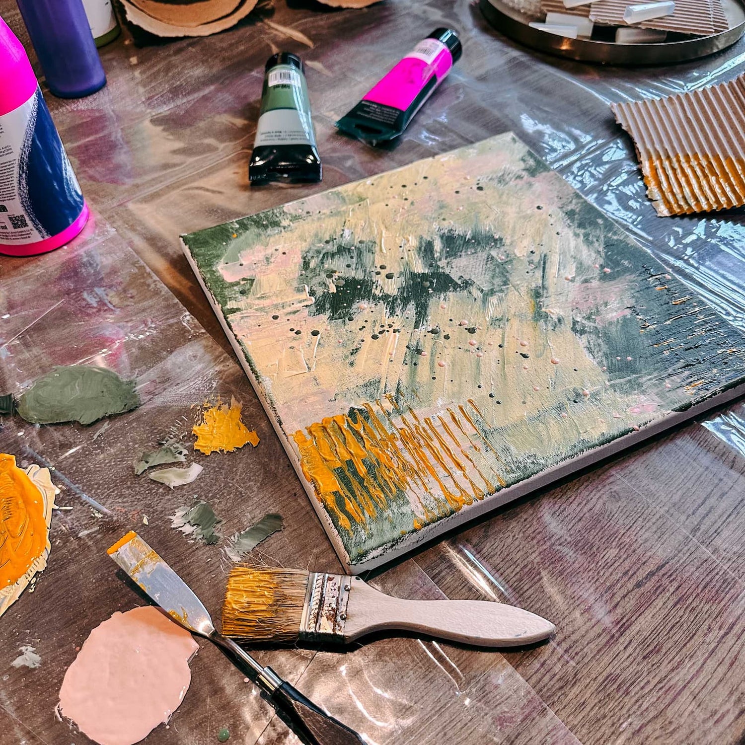 Fertig bemalte Leinwand in Gelb, Grün und Rosa mit kreativen Materialien beim Abstract Painting Workshop von GRIMMS GARTEN Berlin
