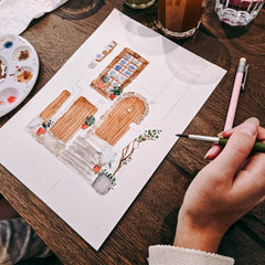 Hände malen eine braune Tür mit Aquarellfarben beim Aquarell Workshop Mediterrane Architektur von GRIMMS GARTEN Berlin