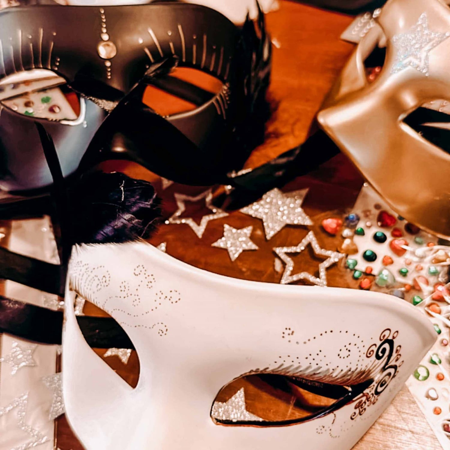 Schwarze, weiße und goldene DIY Masken mit Steinchen und silbernen Glitzersternen beim kreativen Masken Workshop von GRIMMS GARTEN, Teamevent in Berlin