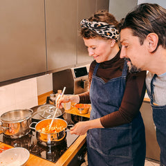 Frau rührt frisches Gemüse im Topf beim Batch Cooking Workshop von GRIMMS GARTEN, Meal Prep Kochkurs in Berlin