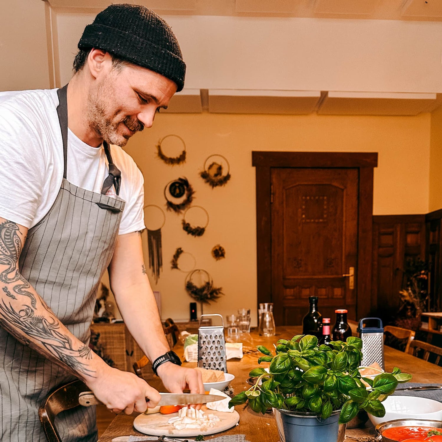 Mann schneidet frisches Gemüse in Stücke beim Batch Cooking Workshop von GRIMMS GARTEN, Meal Prep Kochkurs in Berlin