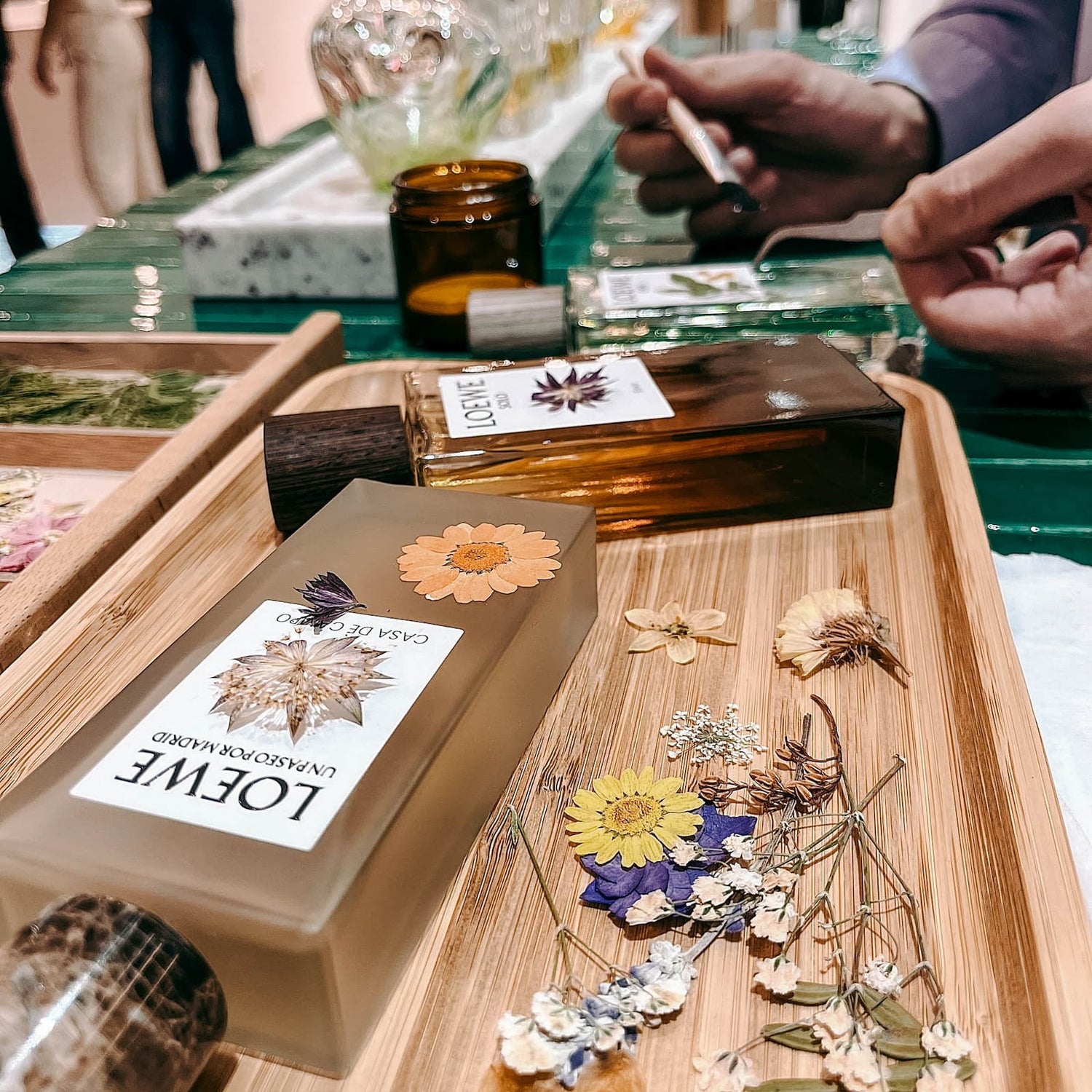 Parfum Flakon wird mit Trockenblumen im kreativen DIY Workshop von GRIMMS GARTEN in Berlin verziert