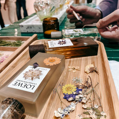 Parfum Flakon wird mit Trockenblumen im kreativen DIY Workshop von GRIMMS GARTEN in Berlin verziert