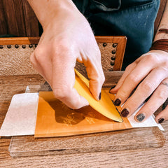 Hand streicht Farbe über Abziehmotiv mit Bienen auf Keramikbecher – DIY Keramik Workshop Berlin, kreativ bemalen