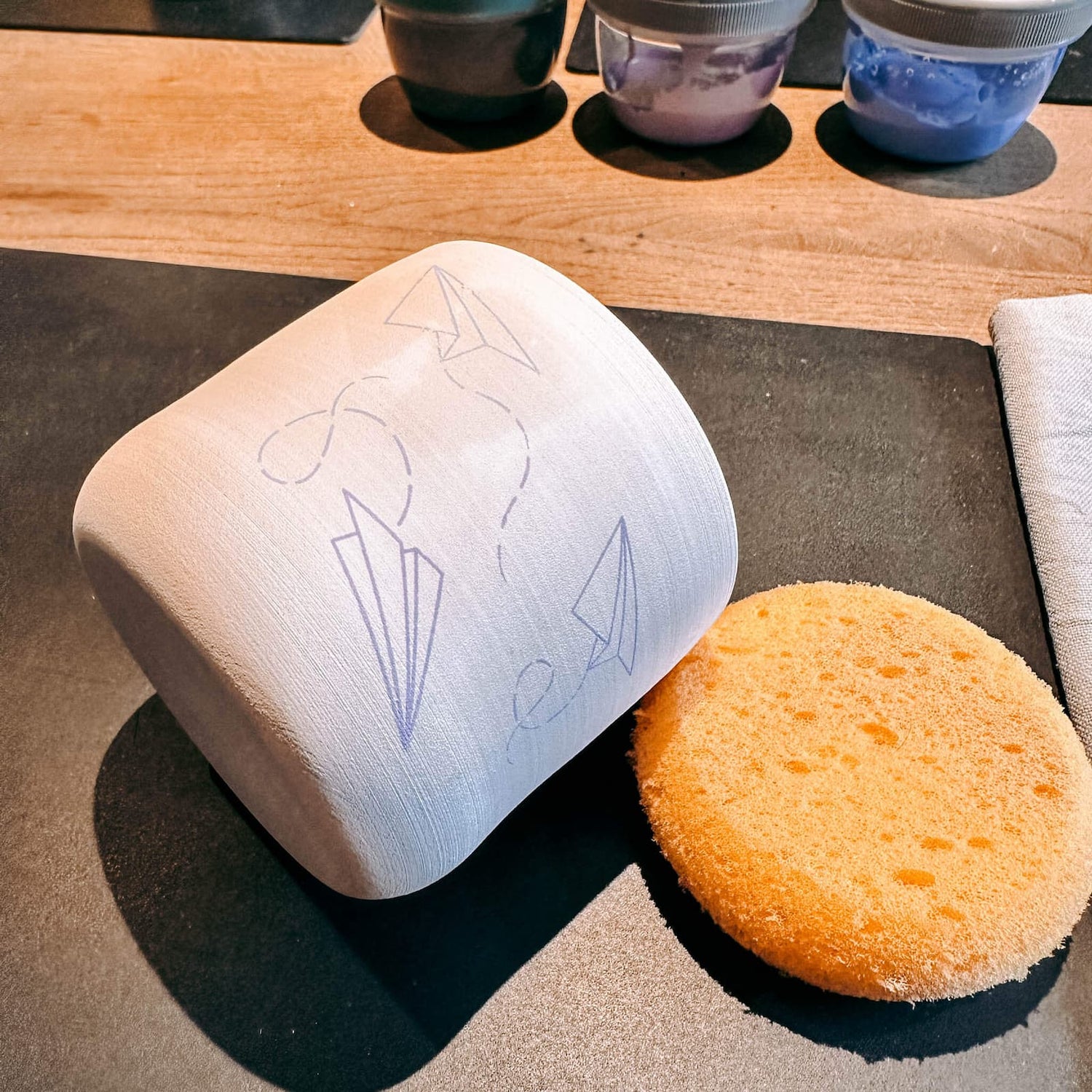 Siebdruck auf Tasse mit Papierflieger-Motiv, kreative Workshop-Arbeit von Grimms Garten