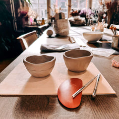 Zwei handgeformte Tontassen mit Töpferwerkzeugen auf rustikaler Holzplatte – Handbuilding Pottery Workshop Grimms Garten