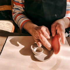 Hände formen Keramik mit Werkzeug zu einer Form beim Töpferkurs von GRIMMS GARTEN, kreativer Keramik Workshop und DIY Kurs in Berlin