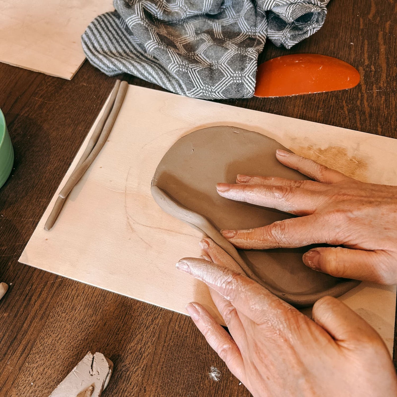 Hände formen weichen Ton zu einer Keramikform beim Töpferkurs von GRIMMS GARTEN, kreativer Keramik Workshop und DIY Kurs in Berlin