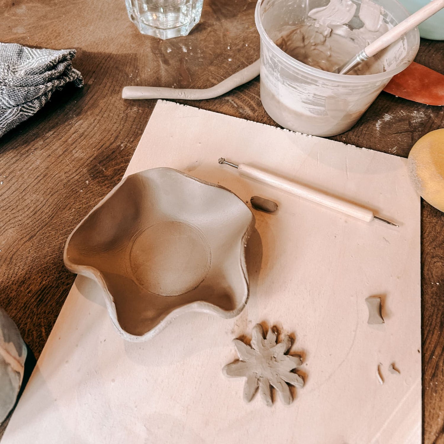 Ausgeschnittener und geformter Ton mit Blumenmotiv beim Töpferkurs von GRIMMS GARTEN, kreativer Keramik Workshop und DIY Kurs in Berlin