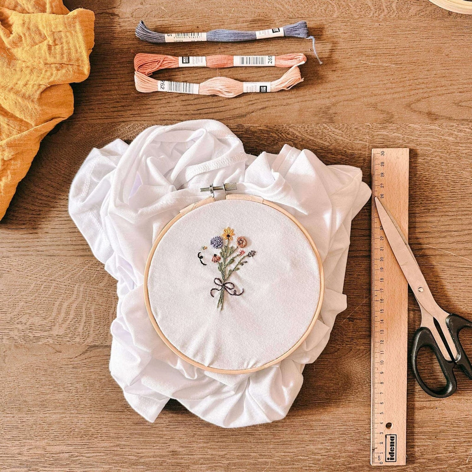 Weißes T-Shirt im Stickrahmen mit Blume, Schere und Garn – sticken workshop, kleidung verzieren, diy mode, embroidery berlin.