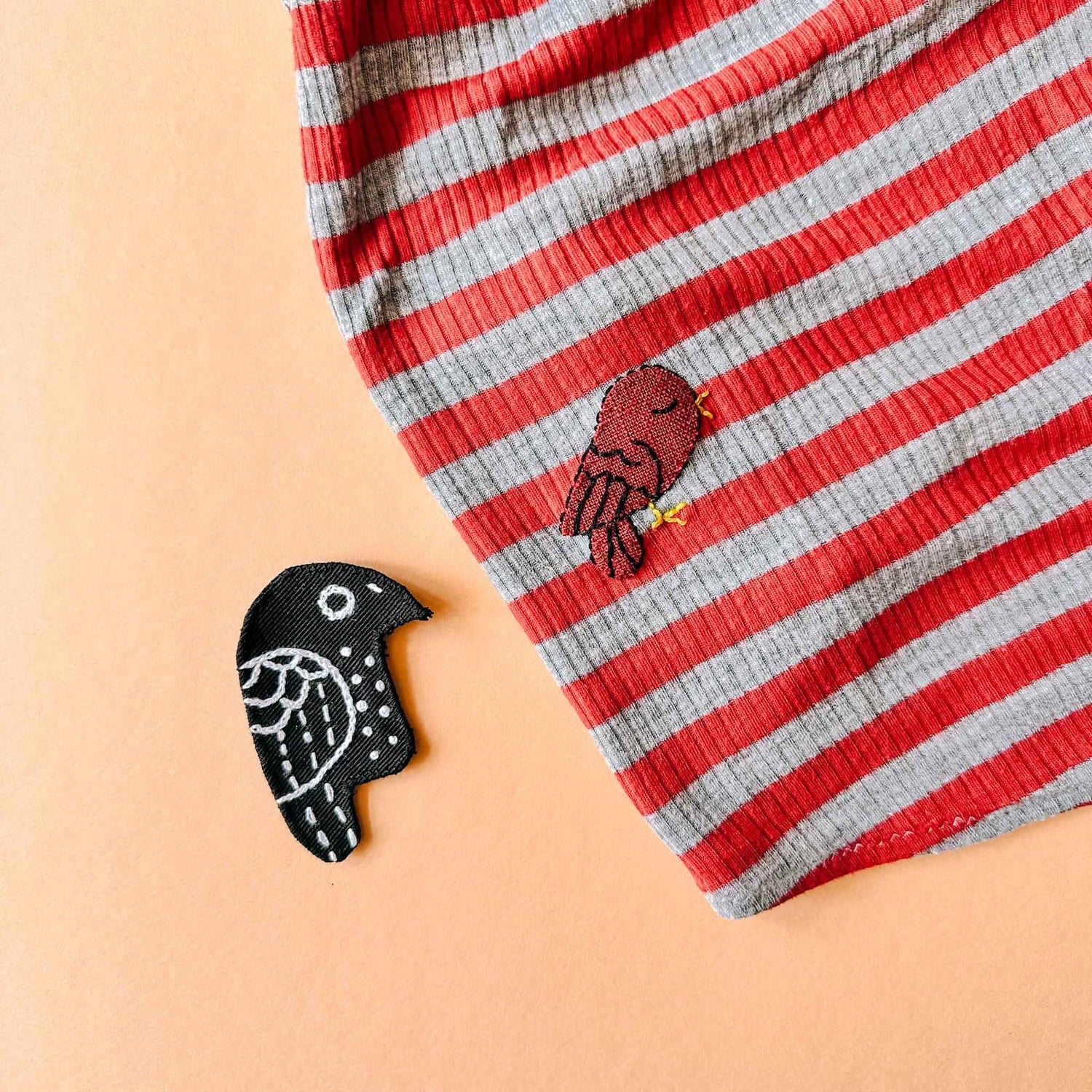 Roter Vogel als gestickter Patch auf gestreiftem Shirt beim Patches nähen Workshop von GRIMMS GARTEN, DIY Nähkurs in Berlin